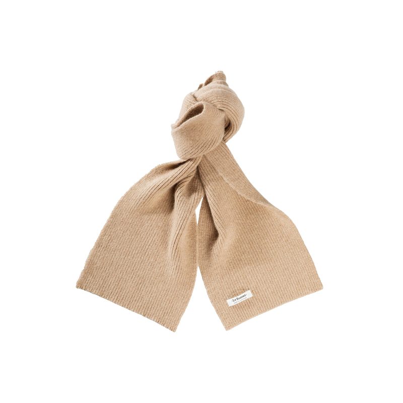 Le Bonnet’s tan ribbed knit lambswool scarf features a stylish knot in the middle and a small label, offering a cozy and elegant addition to your winter wardrobe.